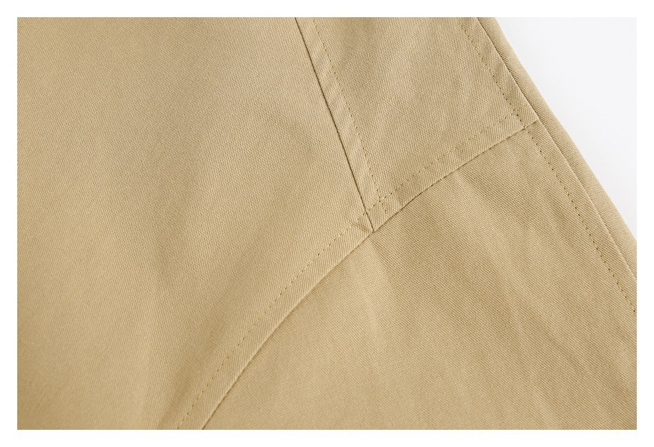 Close-up of tan fabric with intersecting stitched seams.