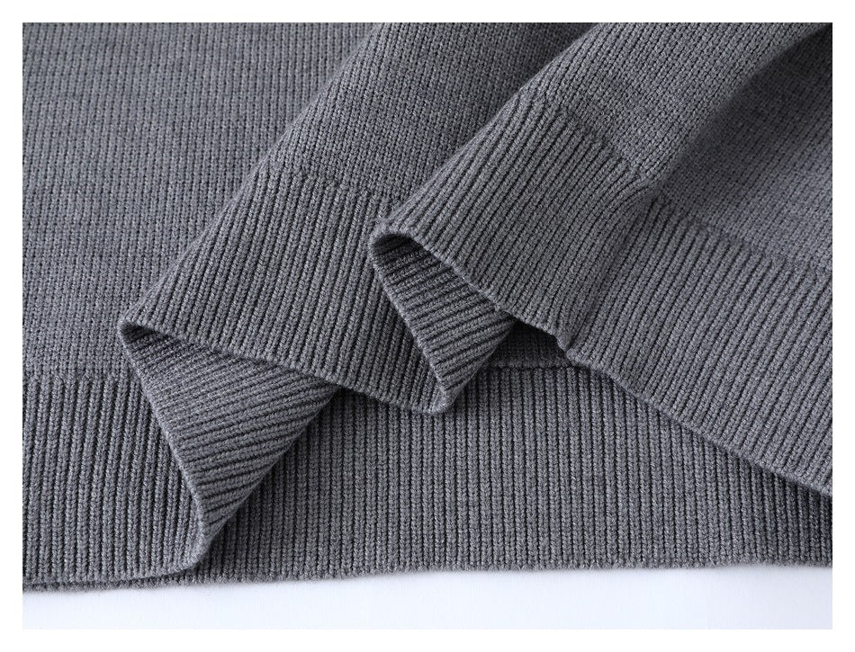 Close-up of the gray sweater's ribbed hem and overlapping ribbed sleeve cuffs.
