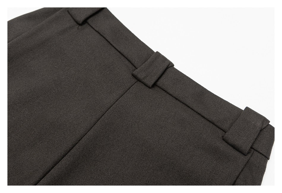Close-up of a dark charcoal trouser waistband with several belt loops.