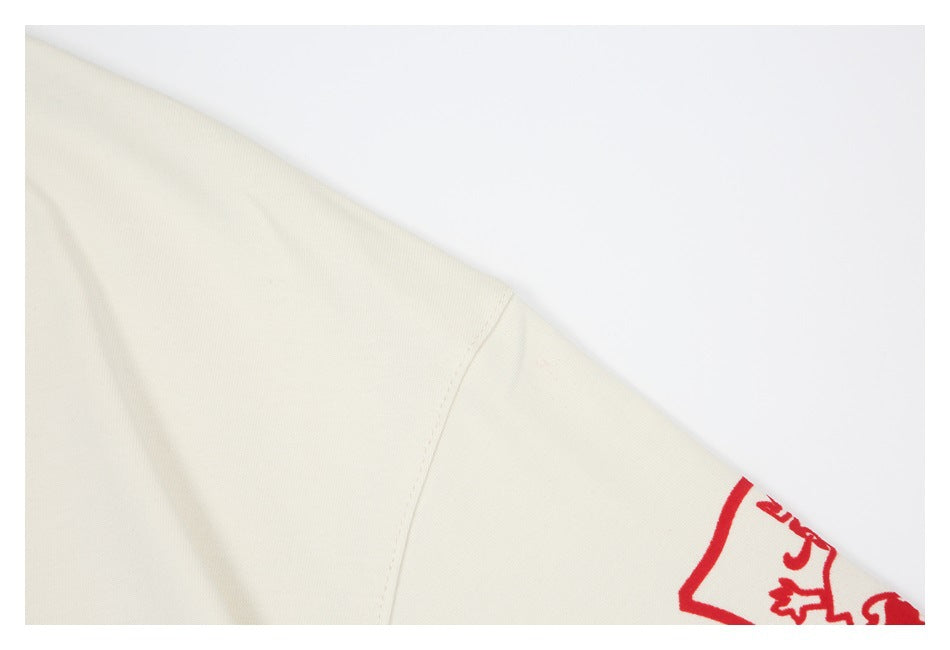 Off-white garment sleeve seam with part of a red printed crest visible at the edge.