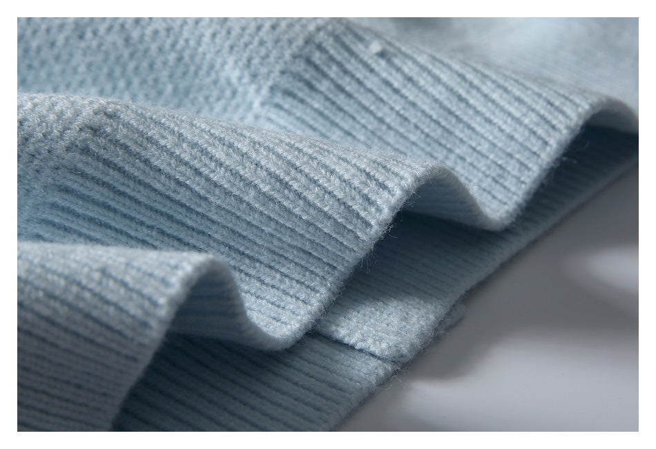 Close-up of the ribbed edge and knit texture of a pale blue garment.