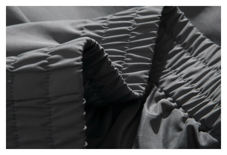 Close-up of charcoal-gray garment with gathered elastic stitching and reinforced seams.