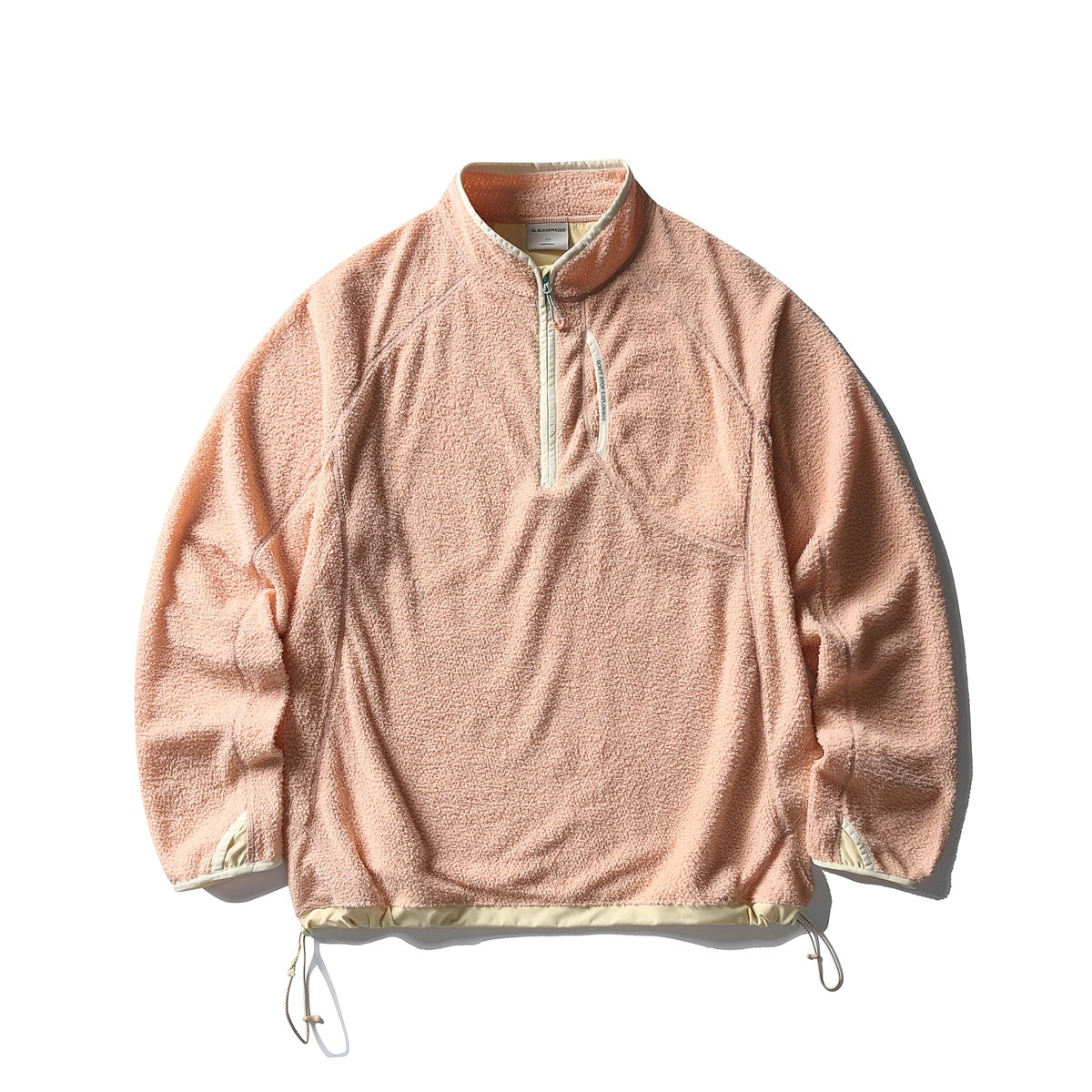 Peach apricot textured fleece-like half-zip pullover with cream trim and drawstring hem, flat lay front view