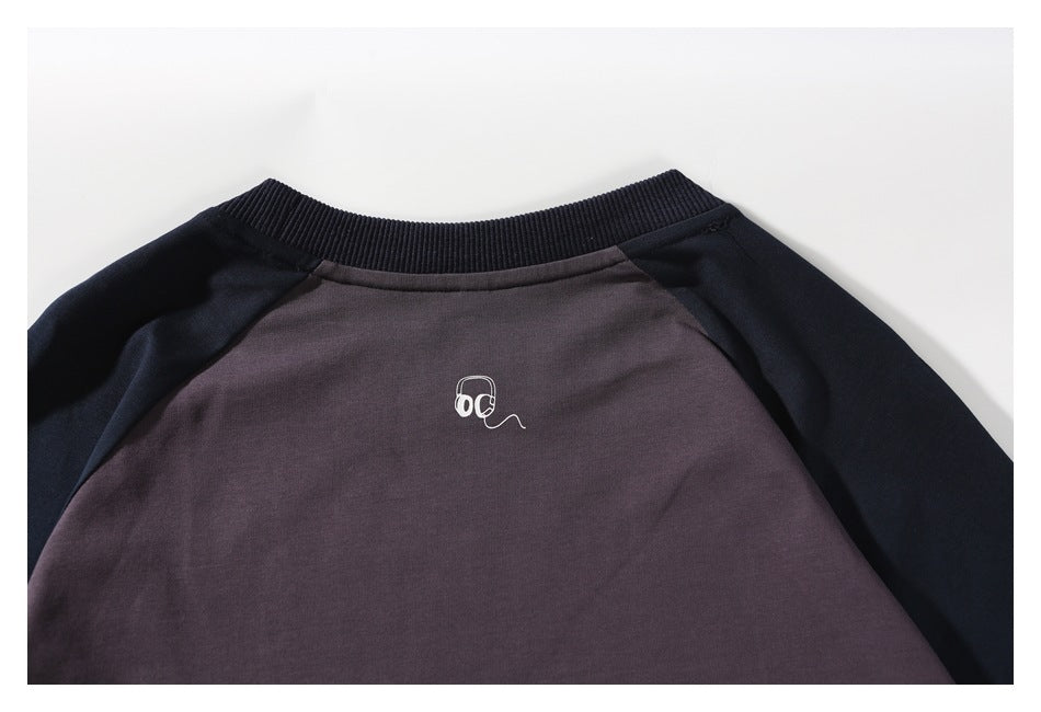 Close-up of the shirt's plum back panel, navy ribbed collar, and small white headphone graphic.