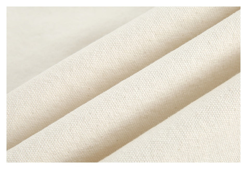Macro view of the ivory garment’s woven texture, gathered into soft folds.