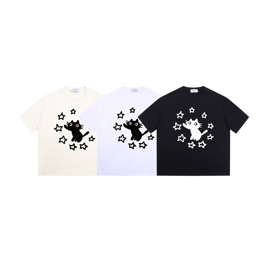 Three short-sleeve T-shirts in cream, white, and black, each with a contrasting cat and star graphic.