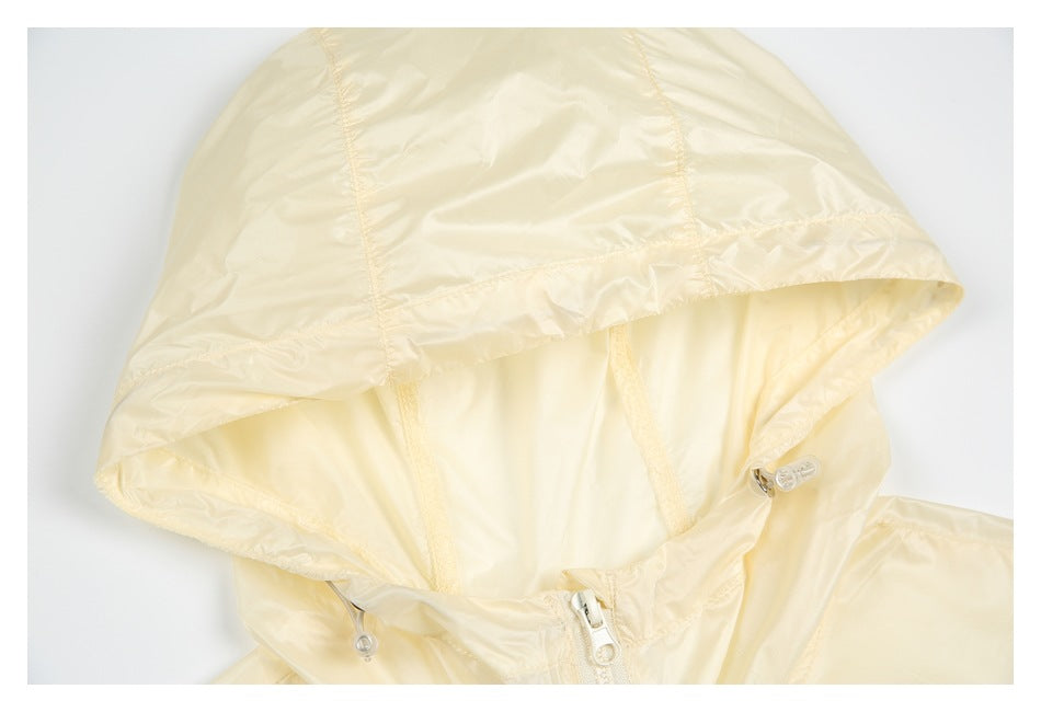 Close-up of a pale cream jacket hood with stitched panels, drawcords and a front zipper.