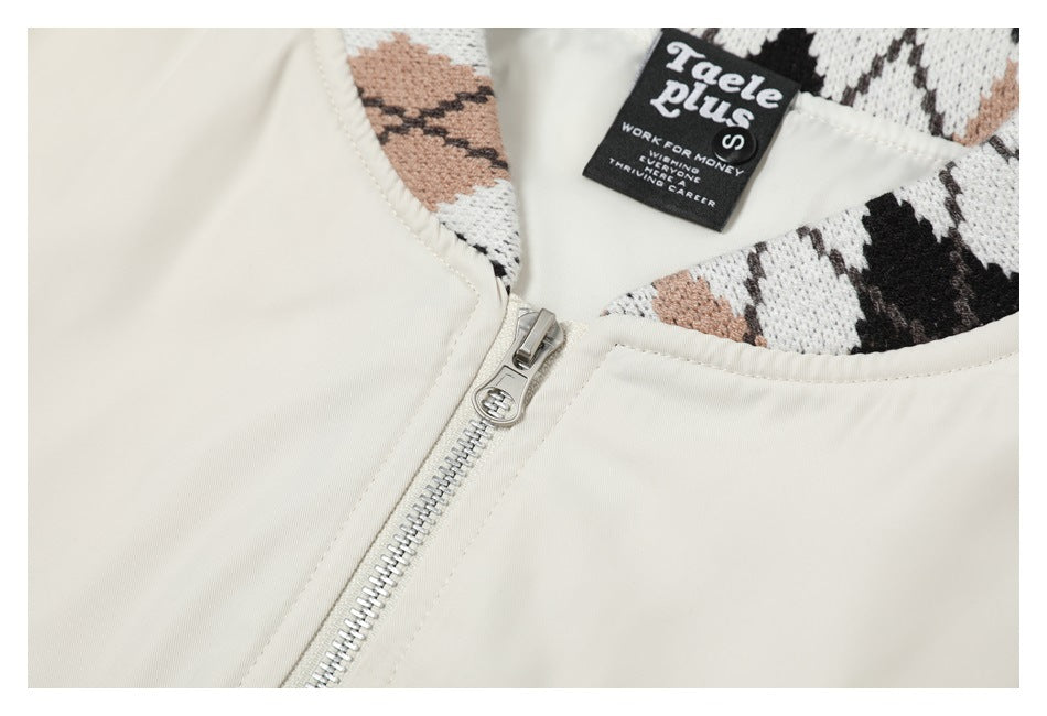 Close-up of the ivory jacket's silver front zipper and patterned collar lining, with a sewn-in black label.