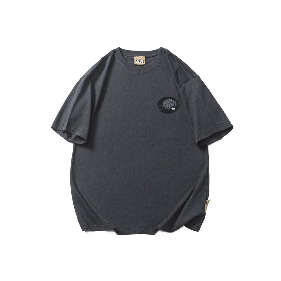 Dark gray short-sleeve crew neck T-shirt with a small black oval cube patch on the left chest, flat front view