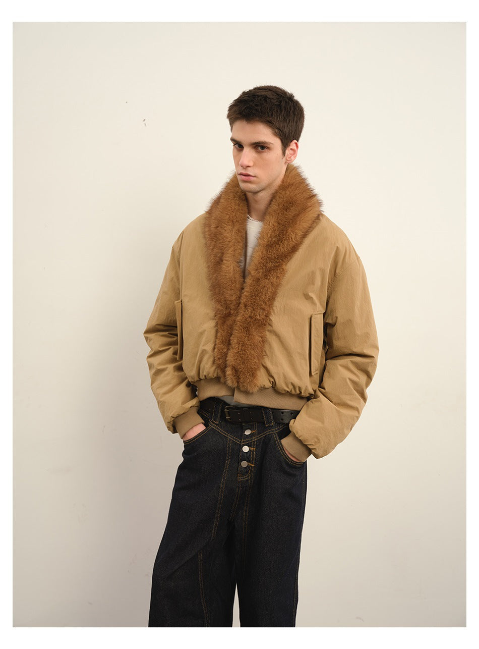 Closer view of a model wearing a tan bomber jacket with a wide brown plush collar and black jeans.