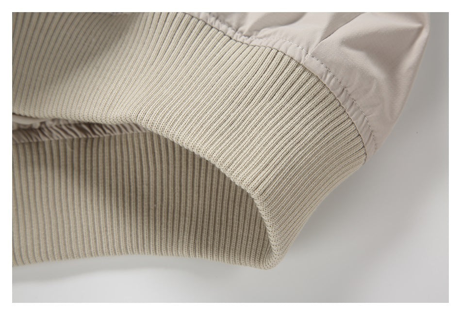 Close-up of the ribbed knit hem on a light beige garment.