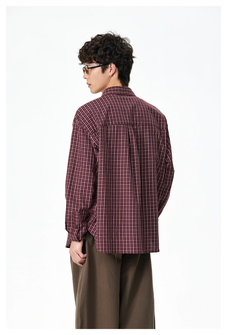 Model shown from the back wearing a burgundy check shirt with a yoke and center pleat.