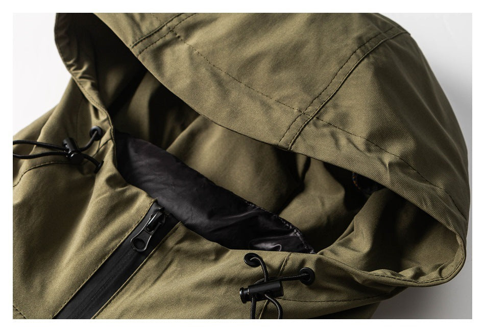 Close-up of an olive-khaki jacket hood with a black zipper, lining, and adjustable drawcord toggles.