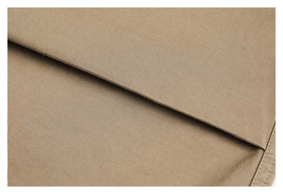 Close-up of the tan fabric surface and folded edge of the pants.