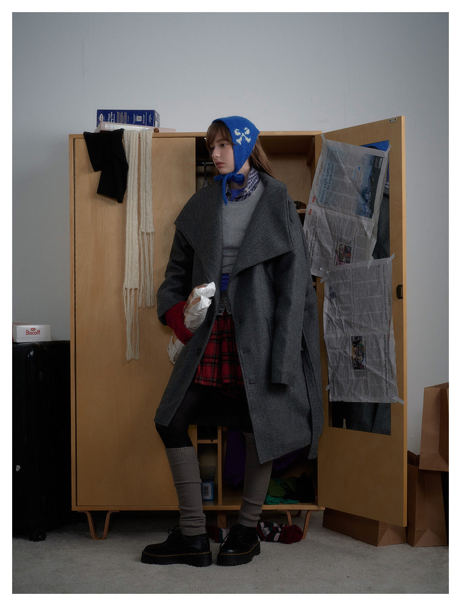 Model in the gray oversized-collar coat turned sideways, showing the coat's length and relaxed drape