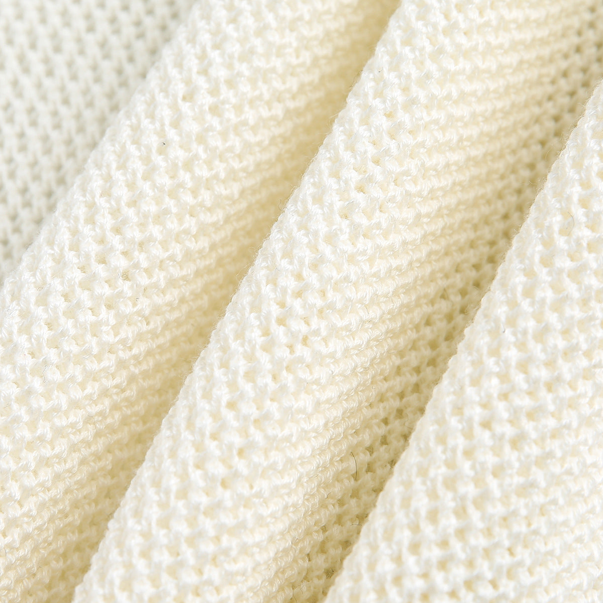 Extreme close-up of the textured ivory knit fabric.