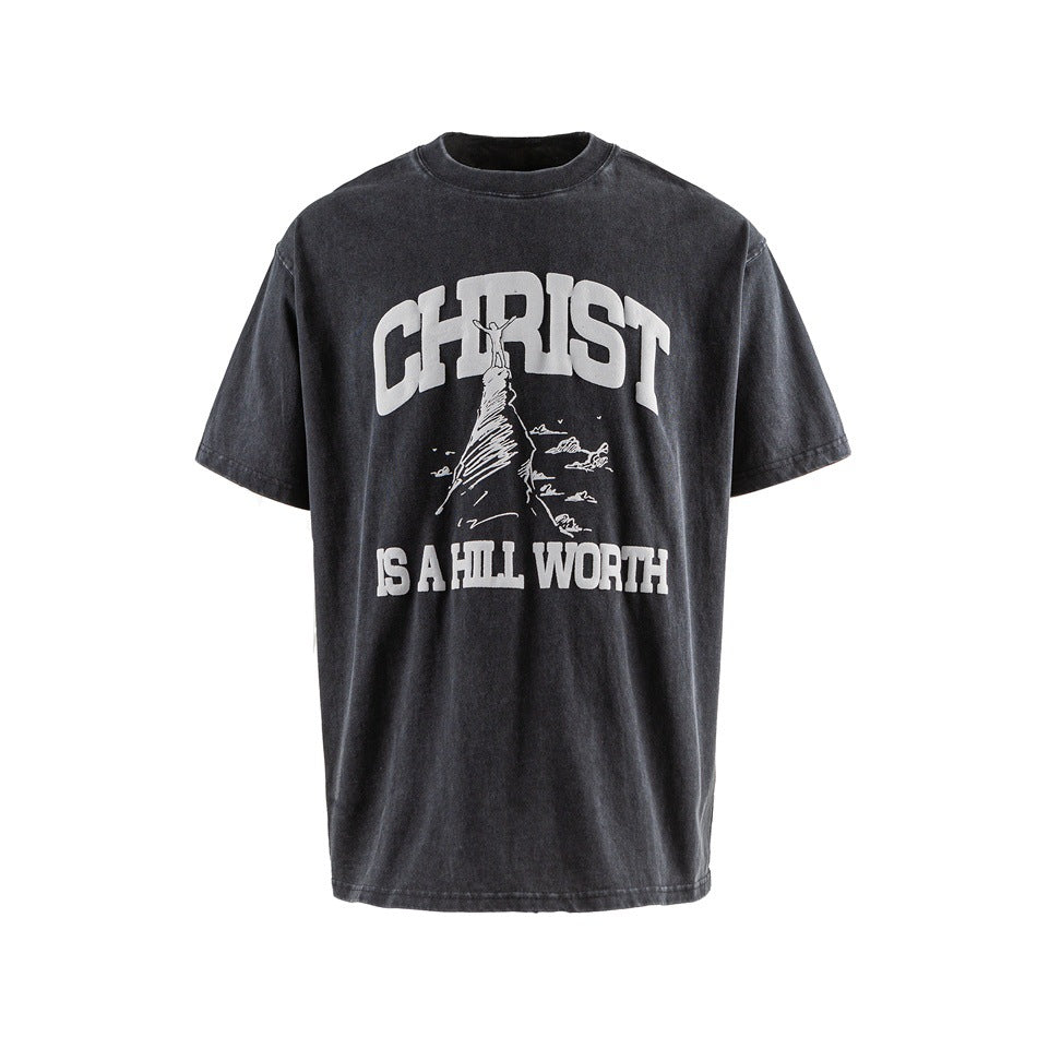 Black washed short-sleeve crew-neck T-shirt with white 'CHRIST IS A HILL WORTH' hill graphic, flat front view