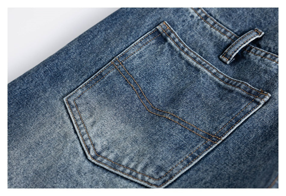 Angled close-up of a back pocket and belt loop on blue denim jeans.