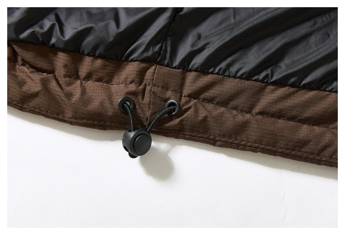Close-up of a black and brown jacket hem with an adjustable black drawcord and toggle.
