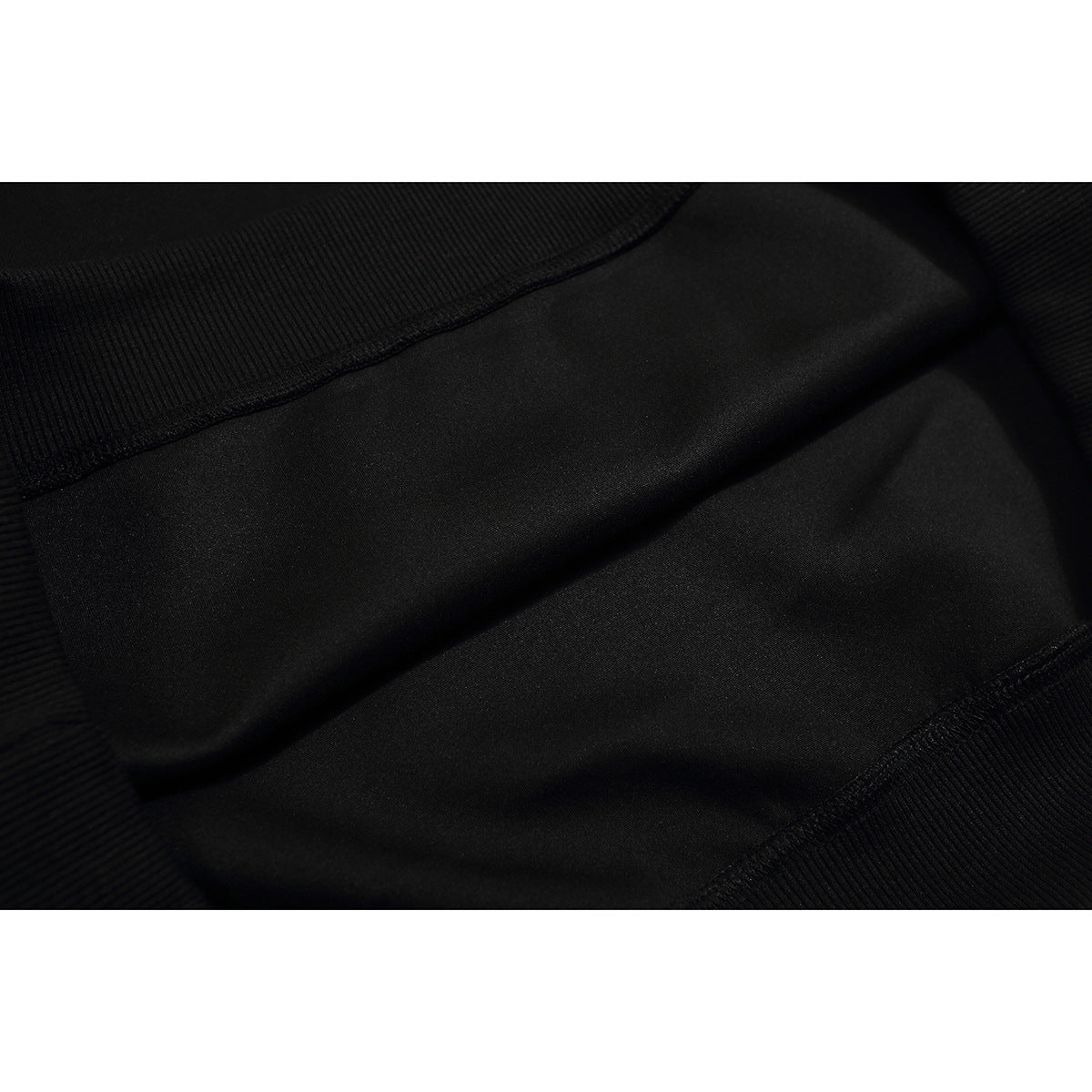 Close-up of black sweatshirt fabric and ribbed seam details.