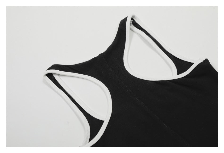 Close-up of a black garment with white binding along the neckline and arm openings.