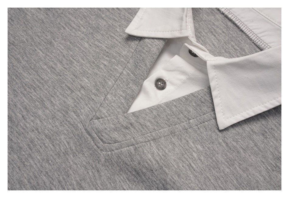 Close-up of the white collar and buttons at the gray pullover's neckline.