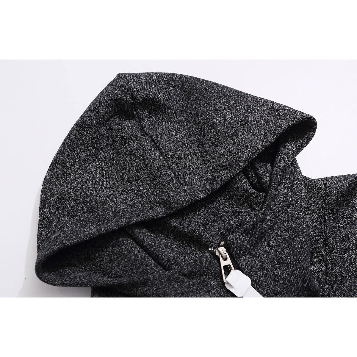 Close-up of a charcoal marled hoodie showing its hood, short front zipper, and white zipper pull.