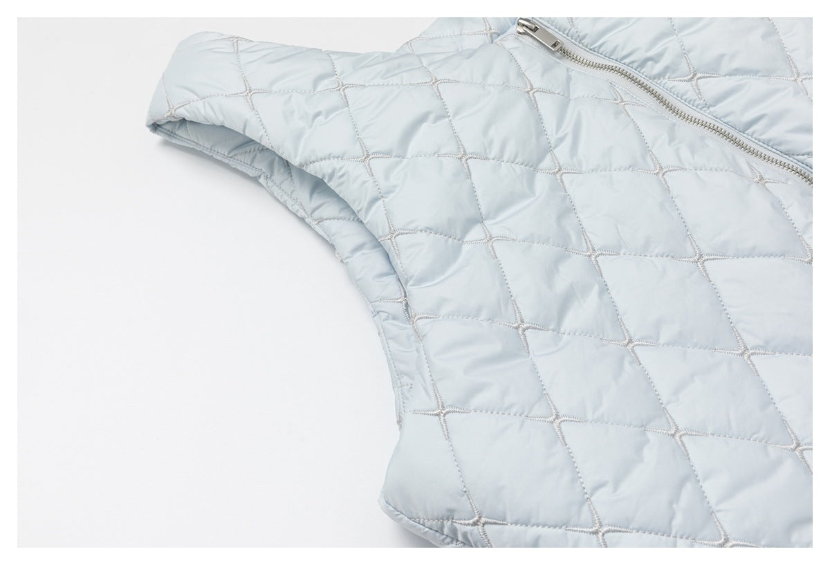 Close-up of pale blue diamond quilting and a silver zipper on the garment.