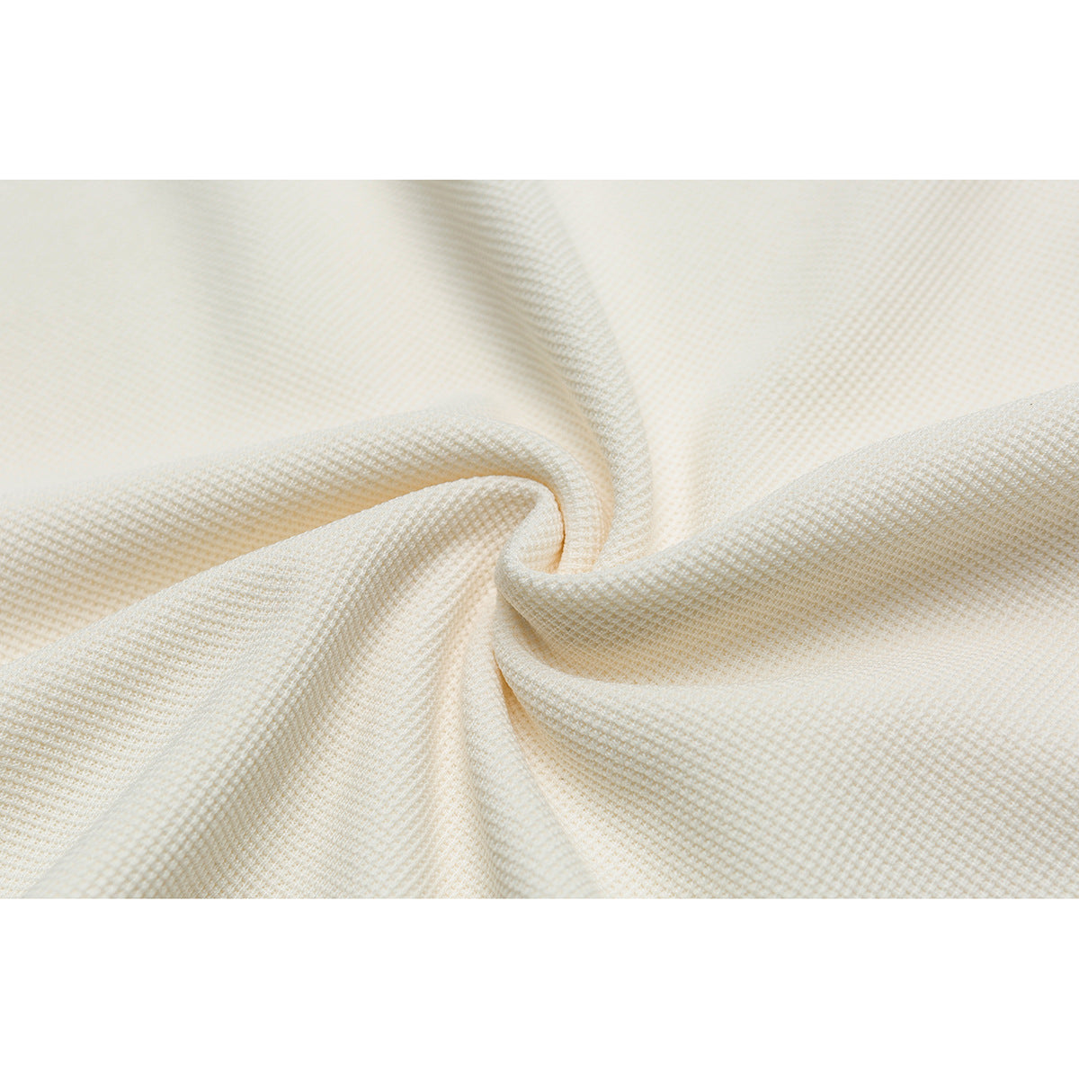 Close-up of ivory fabric gathered to show its small textured weave.