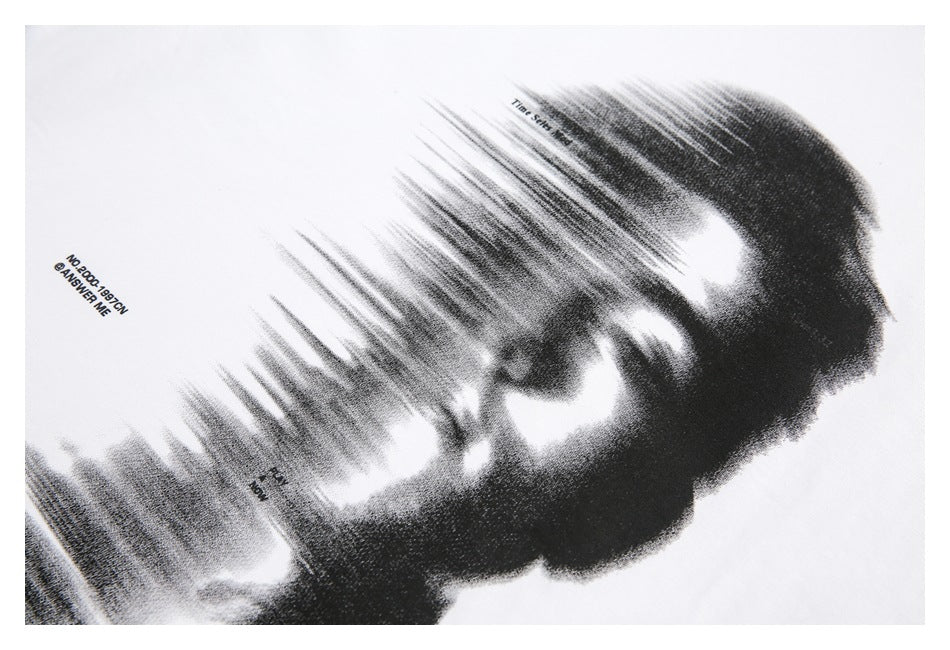 Close-up of a black-and-white portrait graphic with small English text printed on white fabric.