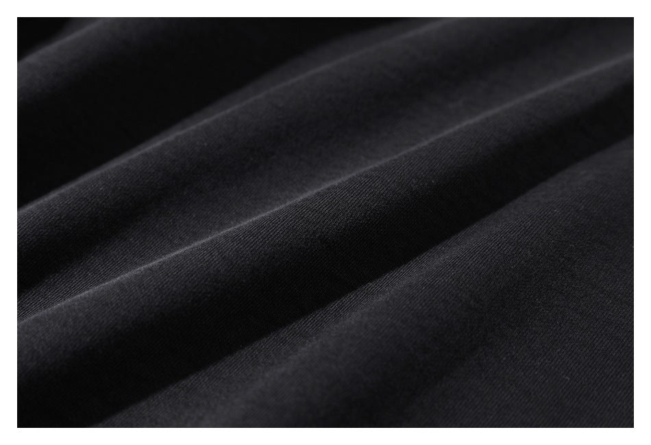 Macro view of the black garment fabric arranged in soft folds.