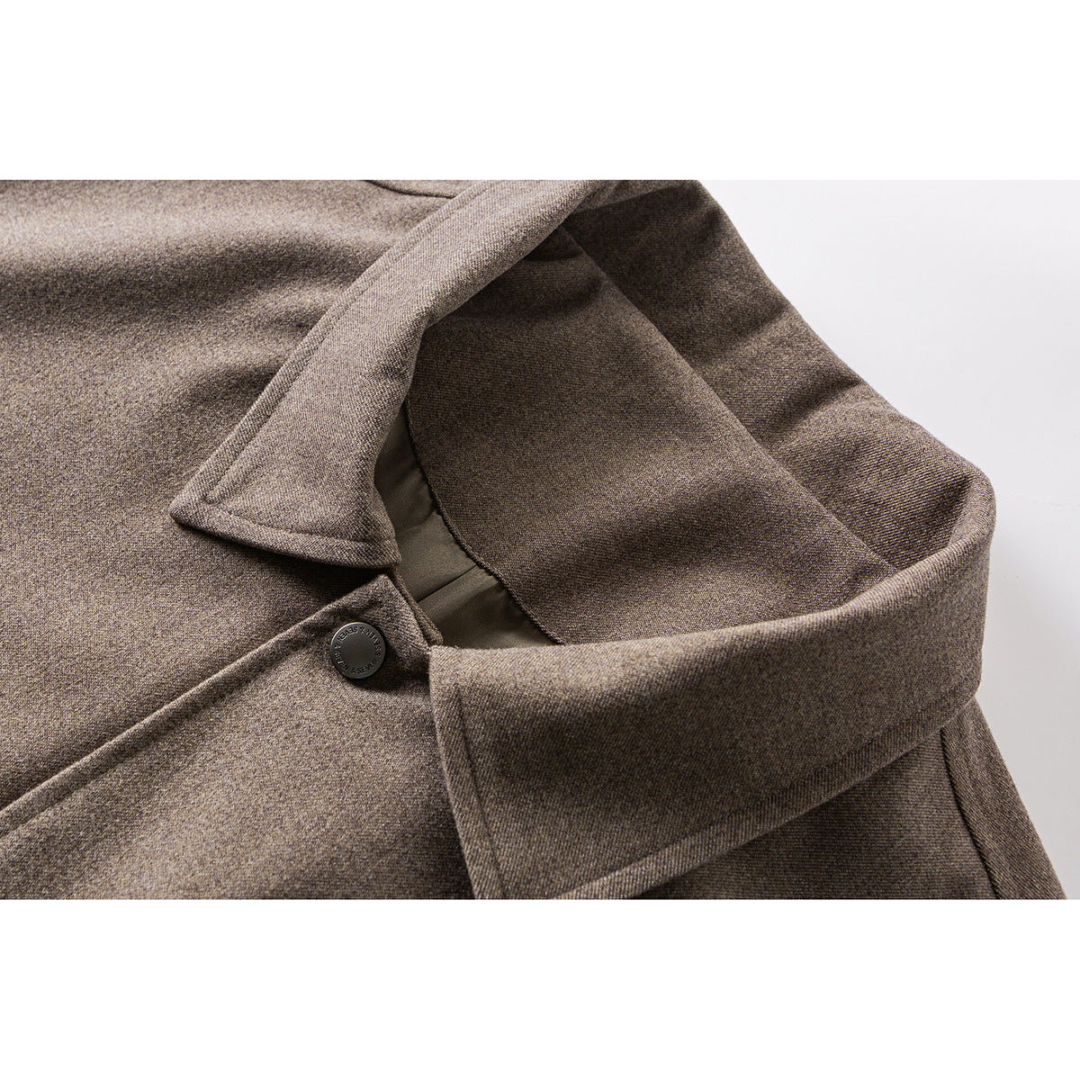 Close-up of a taupe-brown jacket collar, lapel, and dark button.