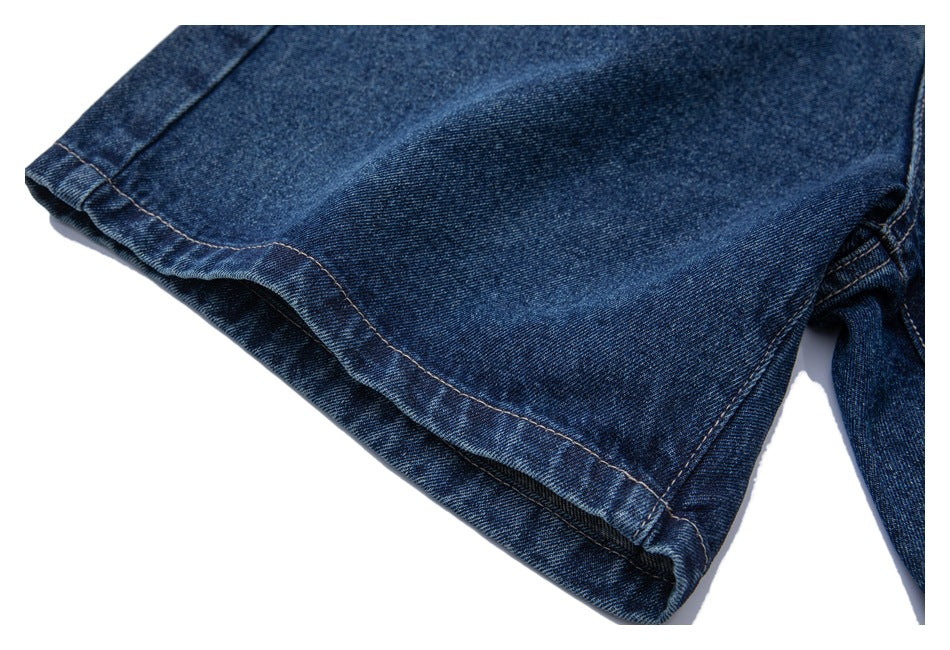 Close-up of the hem and stitching on a dark blue denim jeans leg.