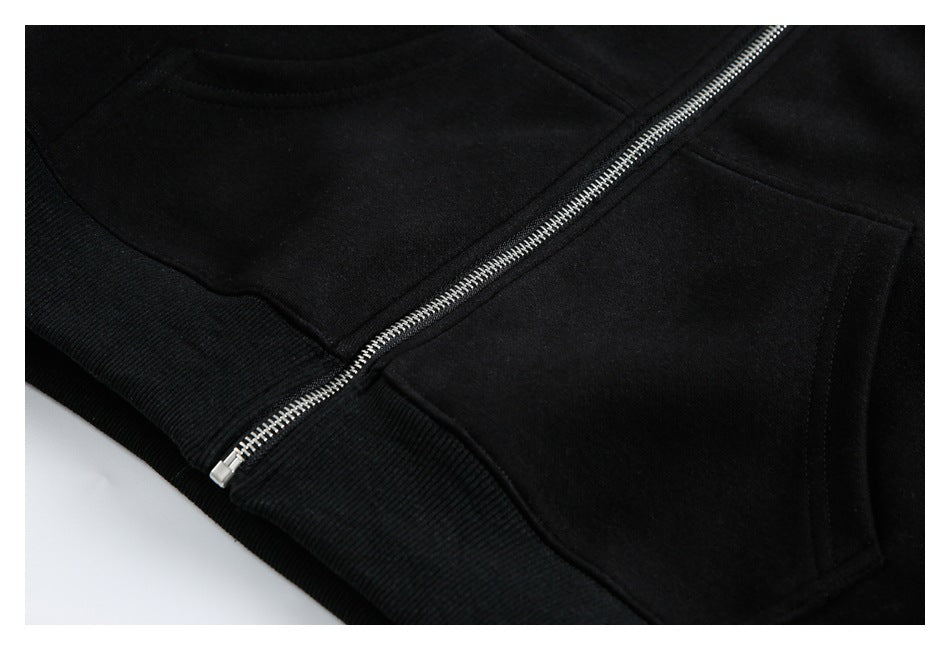 Close-up of a black zip-front garment showing a silver zipper and stitched pocket edge.