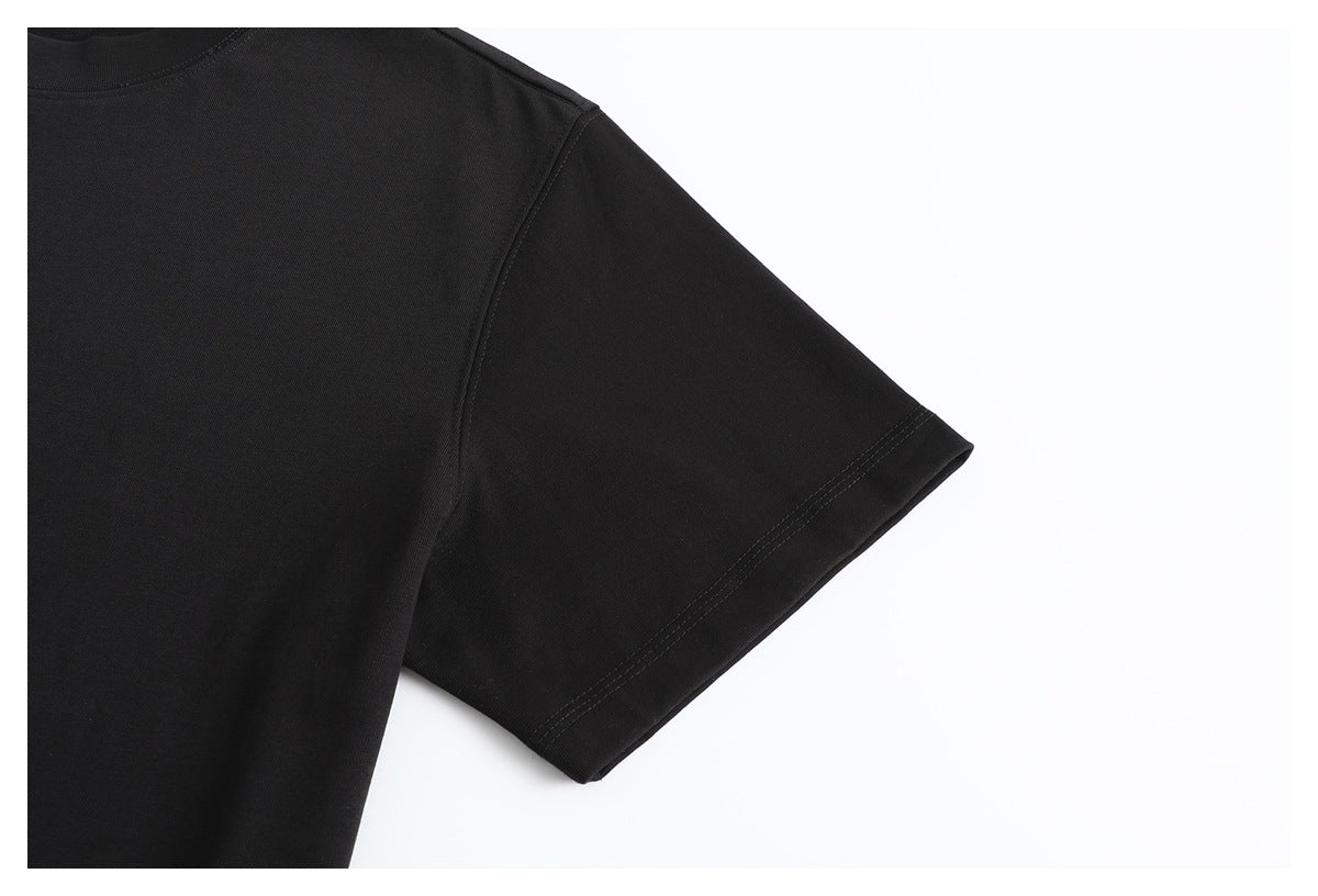 Close-up of a black T-shirt’s short sleeve and shoulder seam against a white background.
