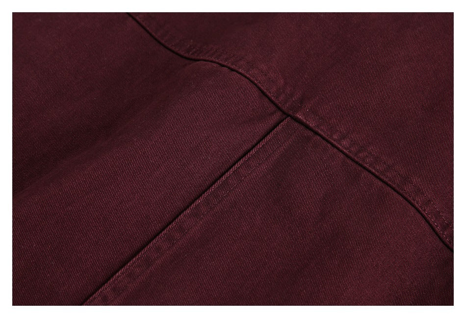 Close-up of burgundy jacket panels meeting at a stitched seam.