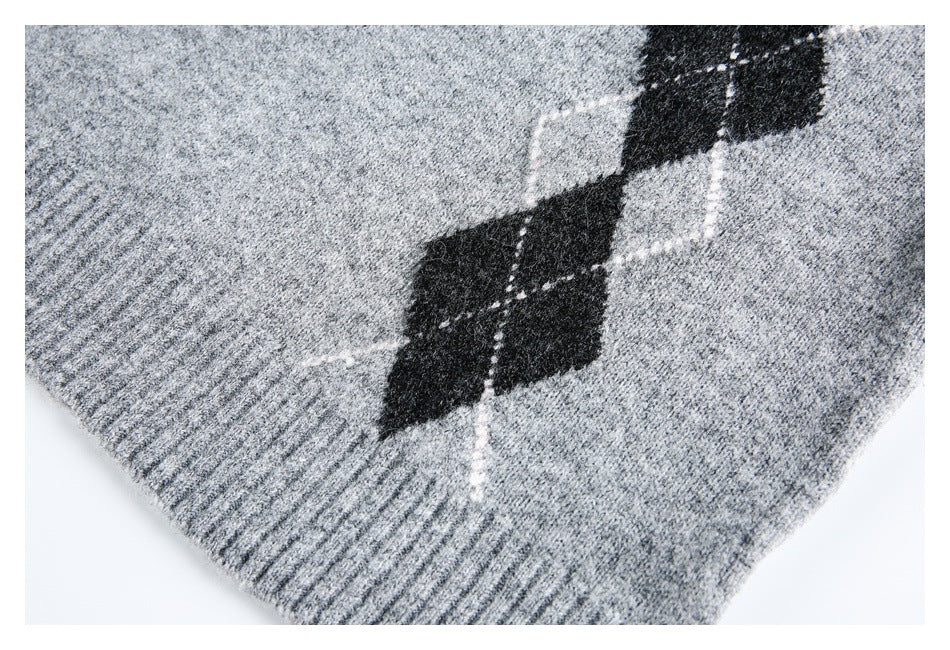 Close-up of the gray marled sweater's ribbed hem and black argyle diamond pattern.