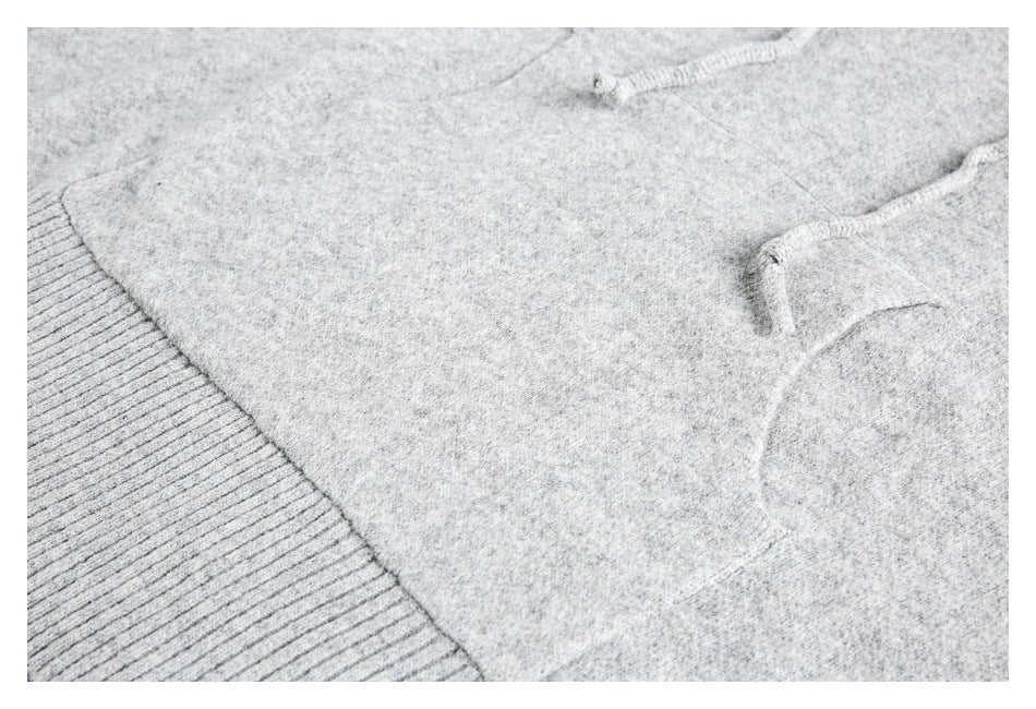 Close-up of a light gray knit garment with a ribbed edge and two small buttons.