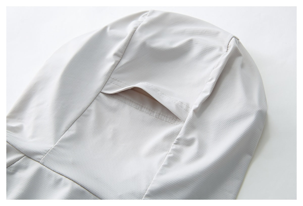Close-up of a vent-like opening between panels on a light gray perforated garment.
