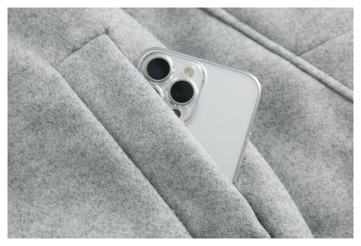 Close-up showing a smartphone tucked into a pocket in the gray jacket.