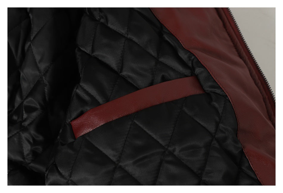 Close-up of black diamond-quilted lining and burgundy trim inside a jacket.