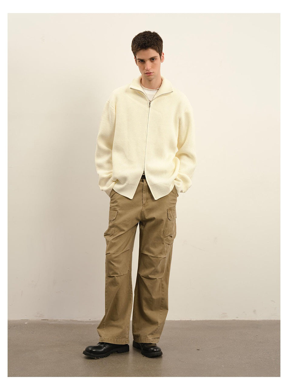 Model wearing an ivory rib-knit zip-front sweater with a high collar and tan cargo pants.