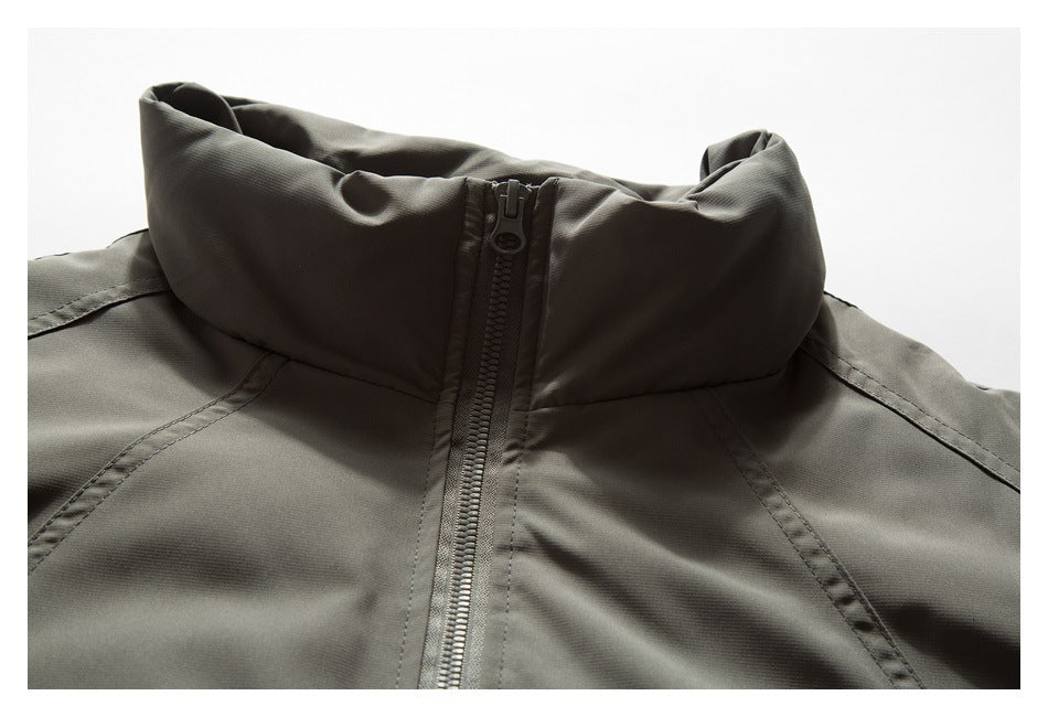 Close-up of an olive-gray jacket's raised stand collar and front zipper.
