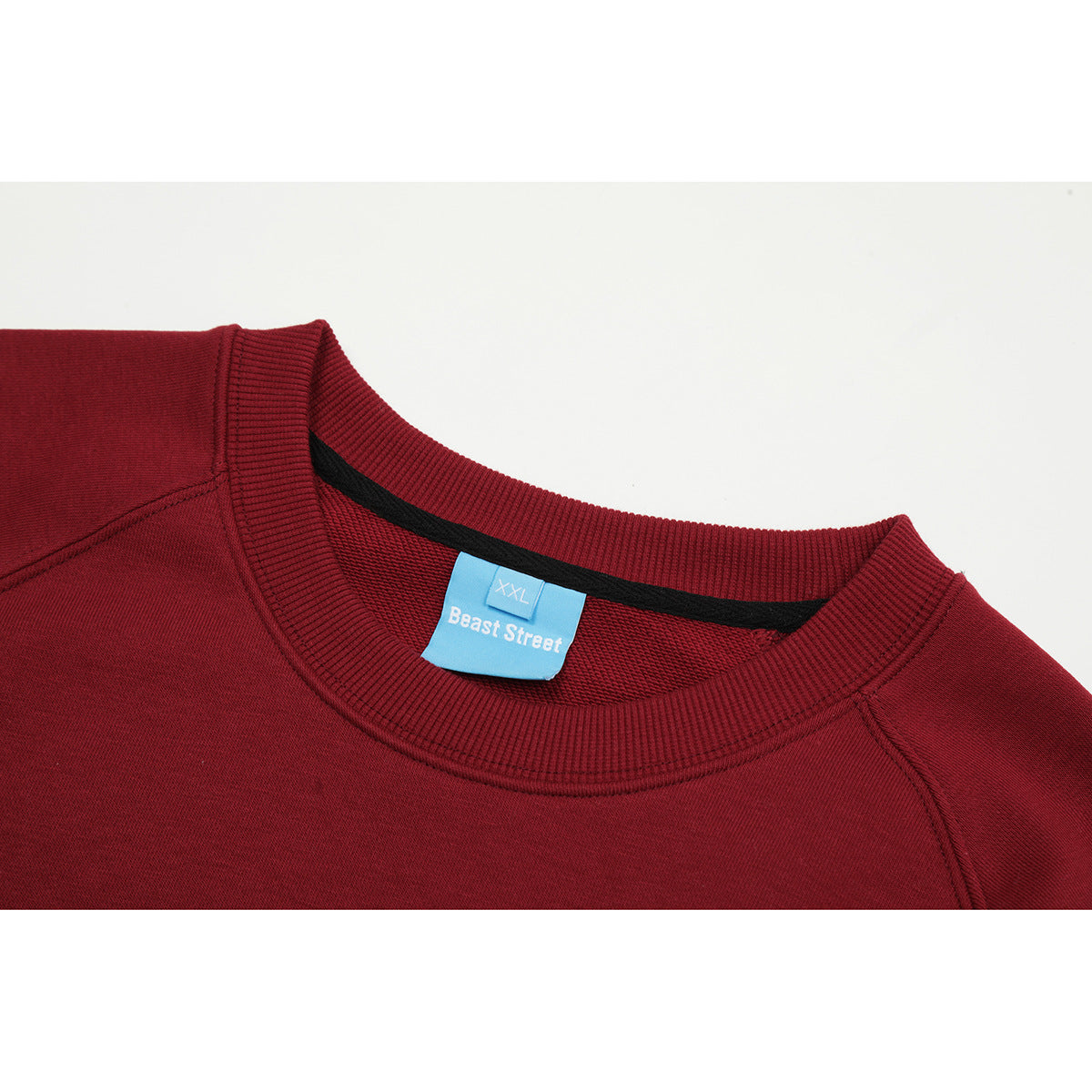 Close-up of a burgundy sweatshirt crew neck with ribbed trim and a blue Beast Street XXL label.