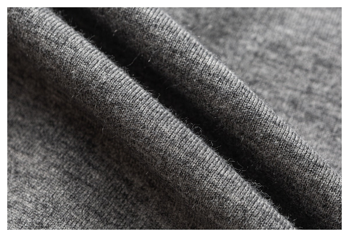 Close-up of dark gray knitted fabric showing its textured stitches and soft-looking fibers.