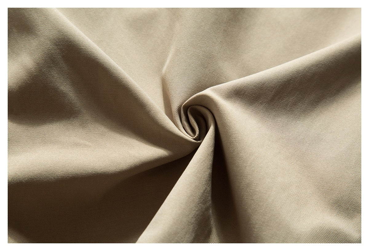 Close-up of beige fabric gathered into folds, showing its fine diagonal weave.