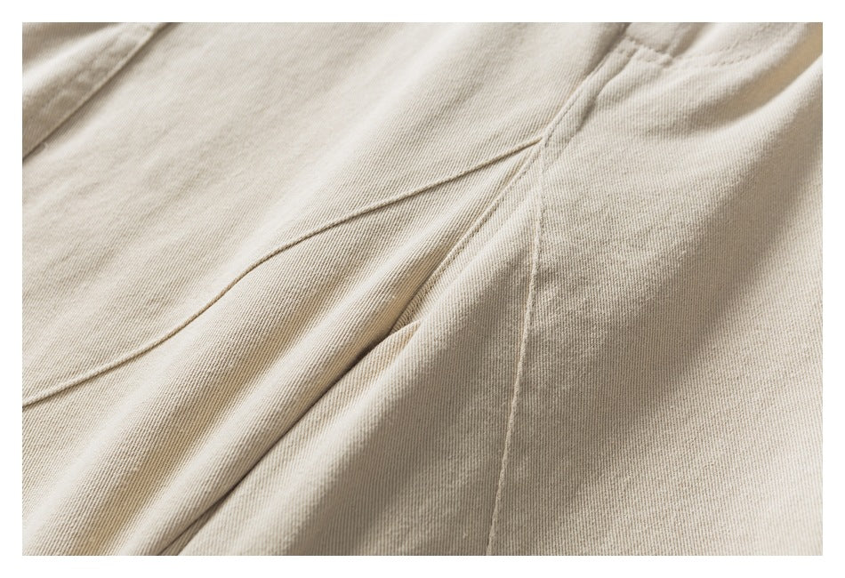 Close-up of beige pants showing a curved stitched seam and fabric texture.