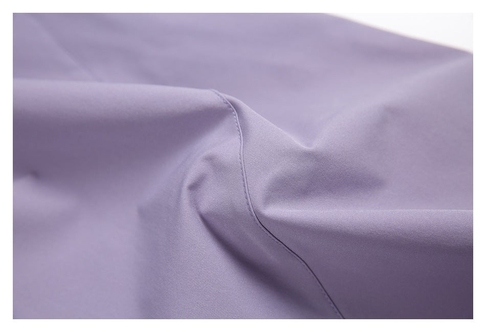 Close-up of smooth lavender fabric with a curved stitched seam and soft folds.