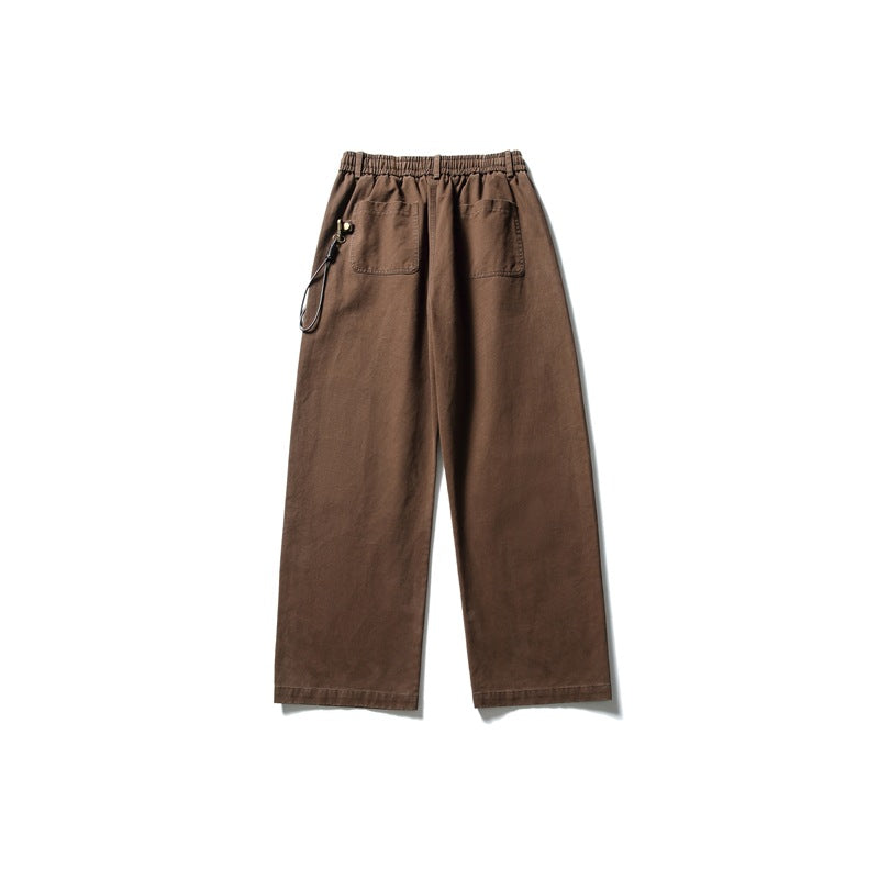 Back view of brown wide-leg trousers with an elastic waist, two patch pockets, and a side cord clip.
