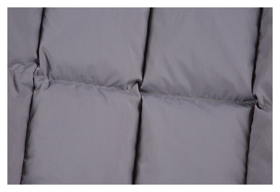 Close-up of gray padded garment with broad quilted panels and visible stitching.